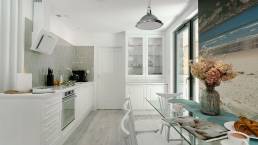Jasny salon apartamentu Sea & Forest z dużymi przeszkleniami, naturalnym światłem i błękitnymi akcentami – fotografia wnętrz premium Międzyzdroje