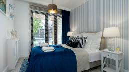 Przytulna sypialnia w apartamencie Sea & Forest z widokiem na zieleń – fotografia wnętrz premium